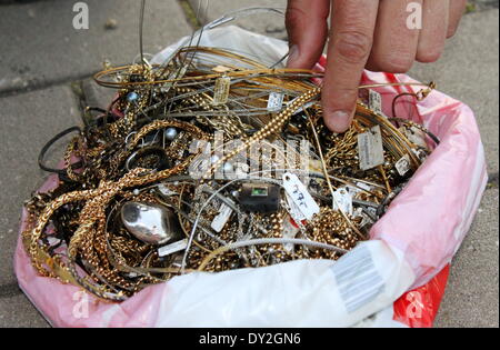 Eine Hand greift in Plastiktüte gefüllt mit Schmuck in Heideck, Deutschland, 3. April 2014. Ein fünfjähriger junge fand den Schatz in einem Teich die erwies sich als wertvoller sein als bisher angenommen. Ein von der örtlichen Polizei schätzten den Wert des Schmucks von mehreren tausend Euro, am 4. April 2014. Teile des Schmucks kam von einem Juwelier aus der Stadt Erlangen, die im Januar 2014 beraubt wurde. Foto: Stephanie Wilcke/Donaukurier/dpa Stockfoto