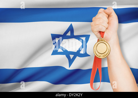 Sportler halten Goldmedaille mit Flagge auf Hintergrund - Staat Israel Stockfoto