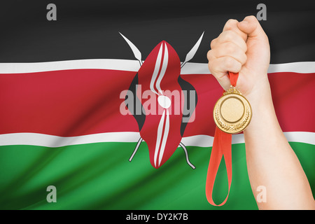 Sportler halten Goldmedaille mit Flagge auf Hintergrund - Republik Kenia Stockfoto