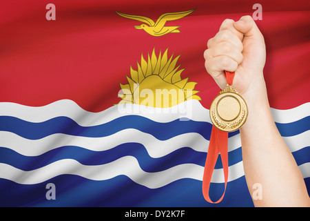 Sportler halten Goldmedaille mit Flagge auf Hintergrund - Republik von Kiribati Stockfoto