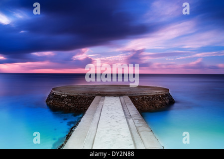 Schönen Pier im Sonnenuntergang, dramatische lila und blau bewölktem Himmel, Ort für romantische Abendessen, Luxus-Resort auf den Malediven Stockfoto