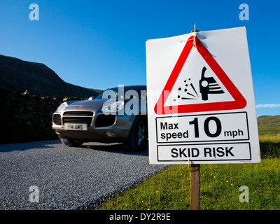 Neu neu asphaltiert Straße mit Skid Risiko Zeichen und 10 km/h Höchstgeschwindigkeit zum Schutz der Fahrer gegen die Gefahr von losen Splitt England UK Stockfoto