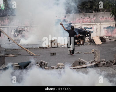 Janosan, Vereinigte Arabische Emirate. 4. April 2014. Ein Demonstrant konfrontiert Polizisten Tränengas aus einem gepanzerten Fahrzeug Feuer. Bahrains Zentrum für Menschenrechte forderte einen Boykott der Insel Formel1 grand-Prix-Veranstaltung stattfinden an diesem Wochenende als sporadische Anti-Regierungs-Proteste im Land weiter. Ahmed Alfardan/NurPhoto/ZUMAPRESS.com/Alamy © Live-Nachrichten Stockfoto