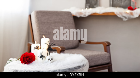 Graue Polsterstuhl in Halloween Ambiente mit Kerzen Stockfoto