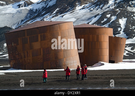 Antarktis Tourismus Whaler es Bay, Deception Island. Touristen aus Kreuzfahrtschiff entdecken Sie in der Nähe von verfallenen Wal Öltanks auf Strand. Stockfoto