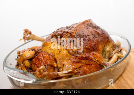 gebratene Gans auf einer Platte auf einem gedeckten Tisch Stockfoto