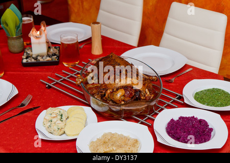 gebratene Gans auf einer Platte auf einem gedeckten Tisch Stockfoto