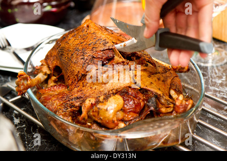 gebratene Gans auf einer Platte auf einem gedeckten Tisch Stockfoto