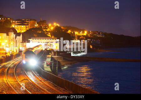 Dawlish, Devon, UK. 4. April 2014. Ein Zug ist gesehen unterwegs für Plymouth für Dawlish am Abend auf ein historischer Tag. Die Riviera Linie Eisenbahnverbindung Exeter, öffnet Plymouth und Penzance zwei Wochen früher als geplant und zwei Monate nach einer Ufermauer verletzt wurde und eine Strecke der Linie wurde schwer beschädigt in Dawlish am 4. Februar 2014 durch große Wellen und Stürme, die viel von der britischen Küste am 4. Februar 2014 getroffen. Bildnachweis: Graham M. Lawrence/Alamy Live-Nachrichten. Stockfoto