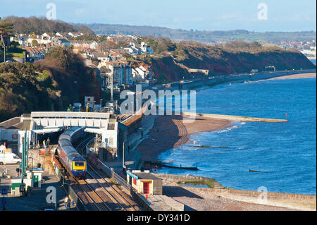 Dawlish, Devon, UK. 4. April 2014. Das Meer ist ruhig, da ein Zug die Station für Plymouth fährt. Die Riviera Linie Eisenbahnverbindung Exeter, öffnet Plymouth und Penzance zwei Wochen früher als geplant und zwei Monate nach einer Ufermauer verletzt wurde und eine Strecke der Linie wurde schwer beschädigt in Dawlish am 4. Februar 2014 durch große Wellen und Stürme, die viel von der britischen Küste am 4. Februar 2014 getroffen. Bildnachweis: Graham M. Lawrence/Alamy Live-Nachrichten. Stockfoto