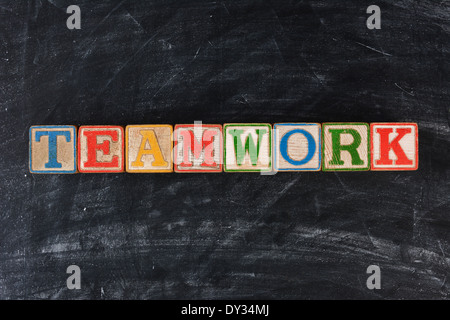 Bunte Kinder-Blöcke Rechtschreibung aus Teamarbeit an einer Tafel. Querformat. Stockfoto