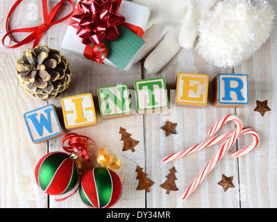 Childrens Blöcke Rechtschreibung aus Winter auf urigen Holzbrettern ist das Wort von Zuckerstangen, Ornamente umgeben. Stockfoto