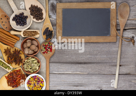 Gewürze auf rustikalem Holzbrett mit Tafel Stockfoto