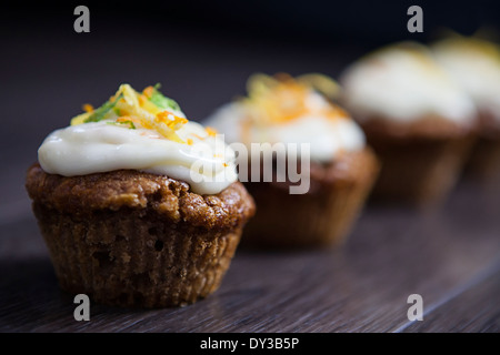 Linie von Cupcakes unscharf vor einem dunklen Hintergrund bewegen. Stockfoto