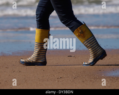 Frau am Strand tragen Gummistiefel, Cornwall, UK Stockfoto