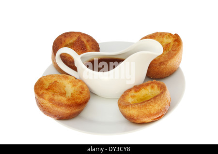 Yorkshire Pudding mit Soße in einen Krug auf einem Teller isoliert gegen weiß Stockfoto