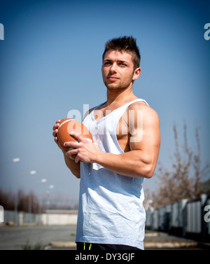 Muskuläre american-Football mit Ball in Hand. Im Freien Schuss Stockfoto