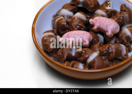 Eine Schüssel mit Schokolade Schweine, gestreifte zwei rosa und die andere braun und weiß. Stockfoto