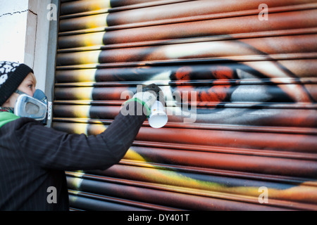 Junge Graffiti-Künstler machen letzten Schliff auf einem Gemälde in Preston Road in London. Stockfoto