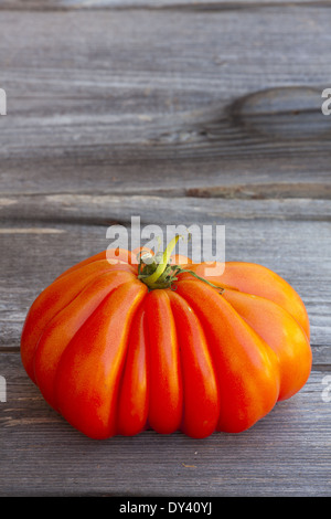 Eine große Beefsteak Tomaten frisch vom Wochenmarkt auf einem alten Holztisch Stockfoto