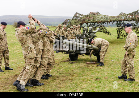 Soldaten aus dem Stamm der Royal Artillery, eine 105 mm heben Lightgun Artillerie zu ermöglichen, einen Kollegen zu stützen, die Räder Stockfoto