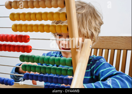 Ein Junge lernt zählen mit einem Abakus Stockfoto