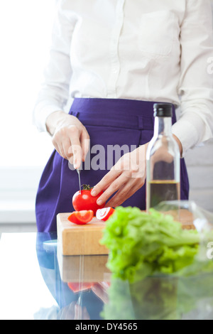 Vertikale Schuss Köchin schneiden Tomate Stockfoto