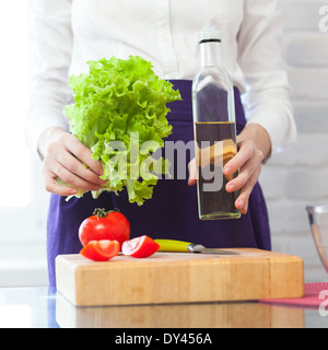 Frau Hände halten eine Salat und Olivenöl Flasche Stockfoto