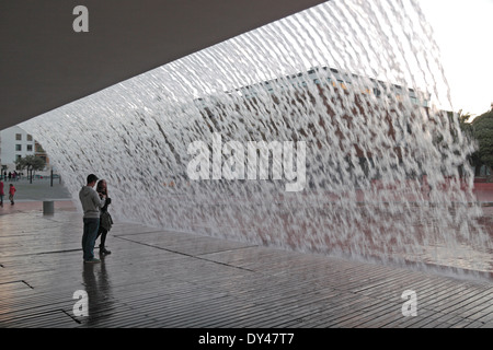 Ein paar Fuß unter einem Wasserfall (das Wasser fällt kontinuierlich über den Pfad) im Parque Das Nações, Lissabon (Lisboa), Portugal. Stockfoto