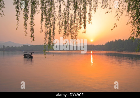 Westsee mit Silhouette einer Zeile Boot bei Sonnenuntergang in Hangzhou, China Stockfoto