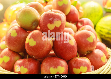 Ein Korb mit Äpfeln mit Herzformen geschnitzt in die Haut Stockfoto