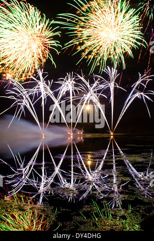 Streifen blau Feuerwerk spiegelt sich in einem trüben See Stockfoto