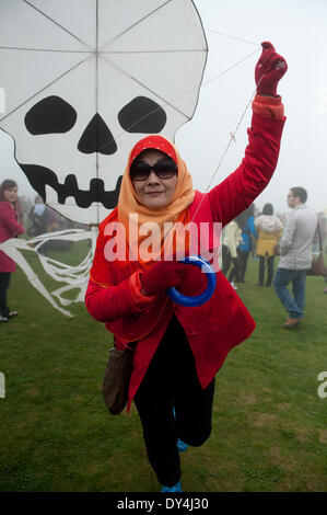 Chongqing, China Chongqing Stadtbezirk. 6. April 2014. Eine Frau aus Malaysia fliegt einen Drachen während Fee Mountain International Kite Festival in Wulong County, Südwest-China Chongqing Stadtbezirk, 6. April 2014. Das Festival startete am Sonntag mit 15 Teams aus verschiedenen Ländern und Regionen, die Teilnahme an dem Drachenfliegen Wettbewerb. Bildnachweis: Meng Tao/Xinhua/Alamy Live-Nachrichten Stockfoto