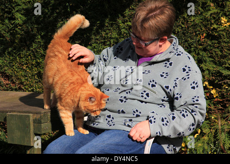 Frau saß im Garten mit Ingwer Katze Stockfoto