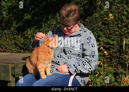 Frau saß im Garten mit Ingwer Katze Stockfoto