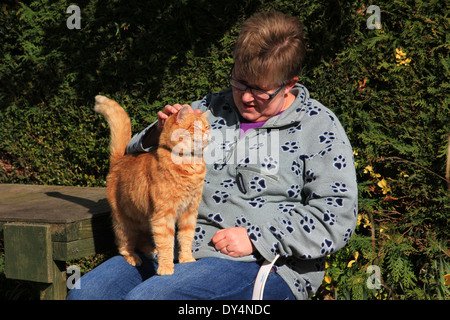 Frau saß im Garten mit Ingwer Katze Stockfoto