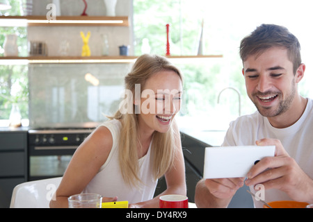 Paar beim Frühstück mit Smartphone