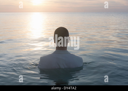 Unternehmer stehen im Meer, Rückansicht Stockfoto