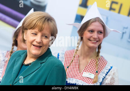 Hannover, Deutschland. 7. April 2014. Bundeskanzlerin Angela Merkel steht neben einer Hostess bei ihrem Eröffnungsrundgang der Hannovermesse 2014 in Hannover, Deutschland, 7. April 2014. Die Fachmesse findet vom 07 April bis 11. April 2014. Das diesjährige Partnerland ist die Niederlande. Foto: JULIAN STRATENSCHULTE/Dpa/Alamy Live News Stockfoto