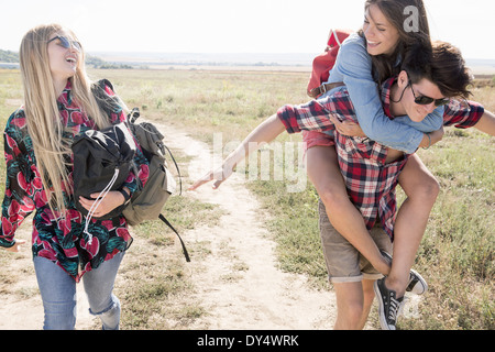 Drei Freunde Wandern, Mann und Frau Huckepack Stockfoto
