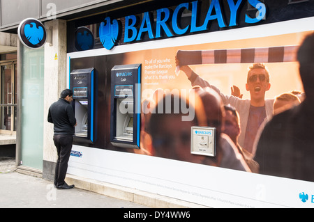 Ein Mann Bargeld von Barclays Geldautomaten in London England Vereinigtes Königreich Großbritannien Stockfoto