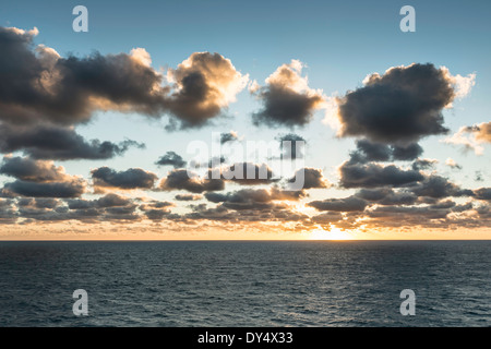 Blaues Meer und sonnendurchflutete Wolken bei Sonnenaufgang