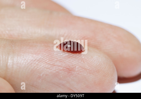 (Synthetisch) Blutstropfen auf einen männlichen finger Stockfoto