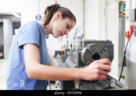 Ingenieurin, die Maschine in der Werkstatt prüfen Stockfoto