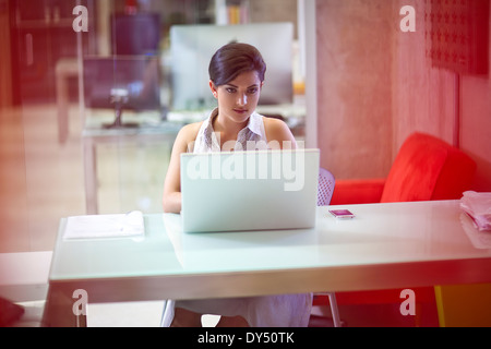 Junge Geschäftsfrau arbeiten am Laptop im Büro Stockfoto