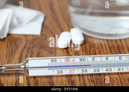 Galinstan Thermometer, erhöhte Körpertemperatur von Fieber, Paracetamol-Tabletten, Glas Wasser, Gewebe Stockfoto