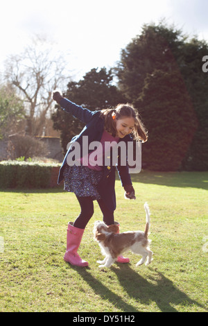 Mädchen spielen mit ihrem Hund im Garten Stockfoto