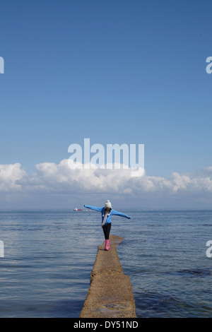 Mädchen, die schmalen Pier an der Küste entlang Stockfoto