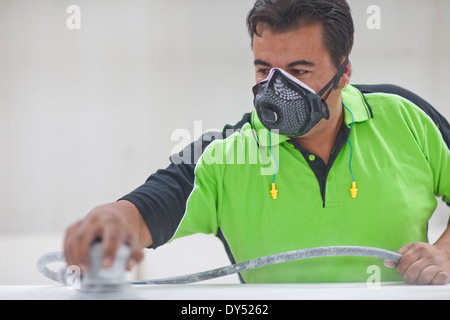 Mann Abschleifen Holzbrett in Tischler Werkstatt Stockfoto