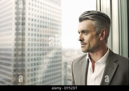 Porträt von reifer Geschäftsmann aus Bürofenster Stockfoto